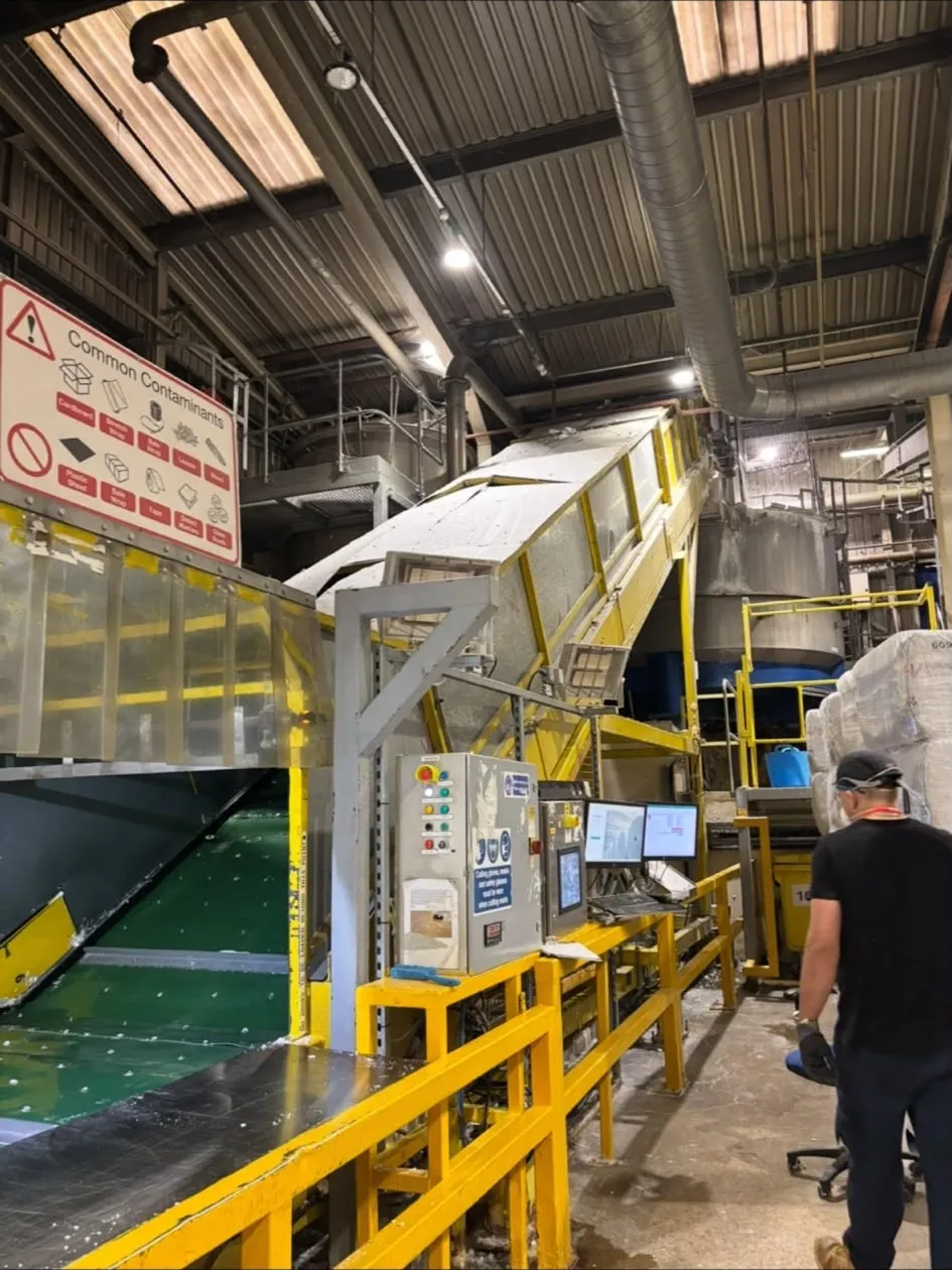 An overhead gantry crane above machine rolls in a mill workshop.